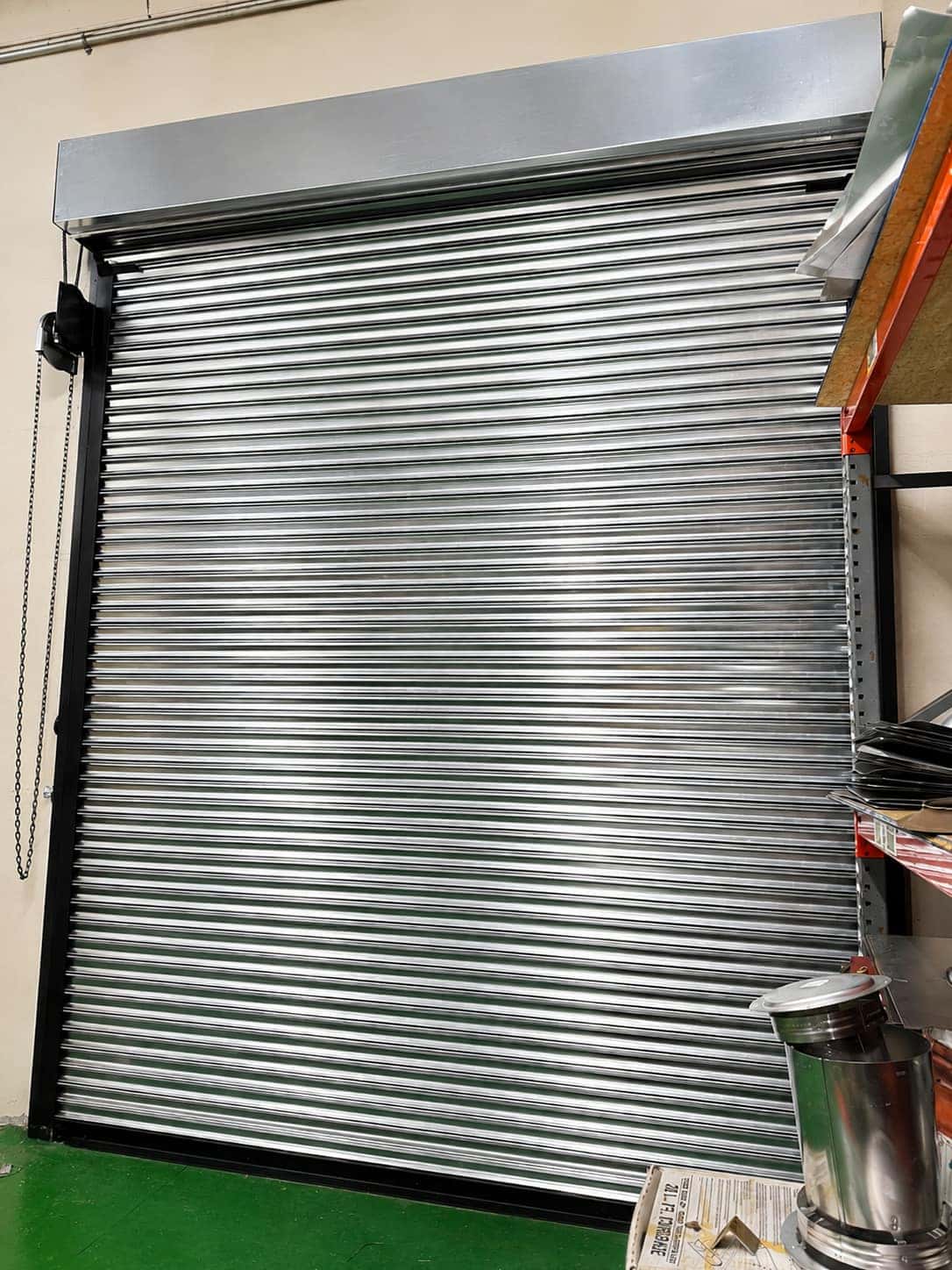 Heavy gauge galvanized rolling steel service door installed inside a warehouse bay