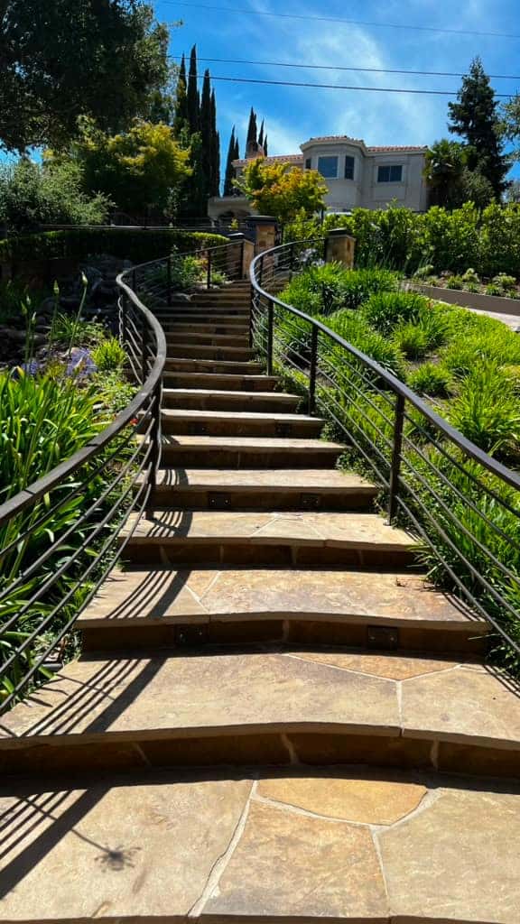 Metal fence and railing engineered to follow a hillside grade