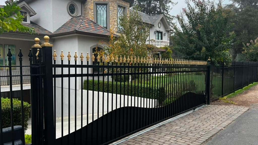 Ornamental iron estate fence with decorative finials along an upscale property
