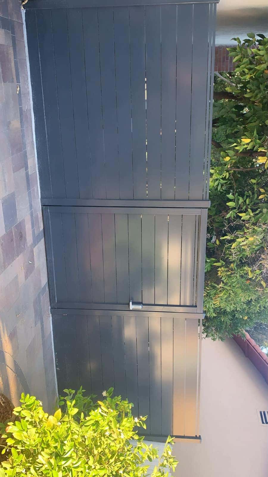 Tall dark vertical-board wood privacy fence