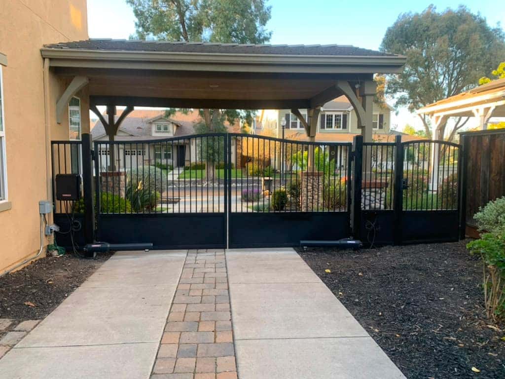 Modern black-slat automatic gate with controlled entry at a carport driveway