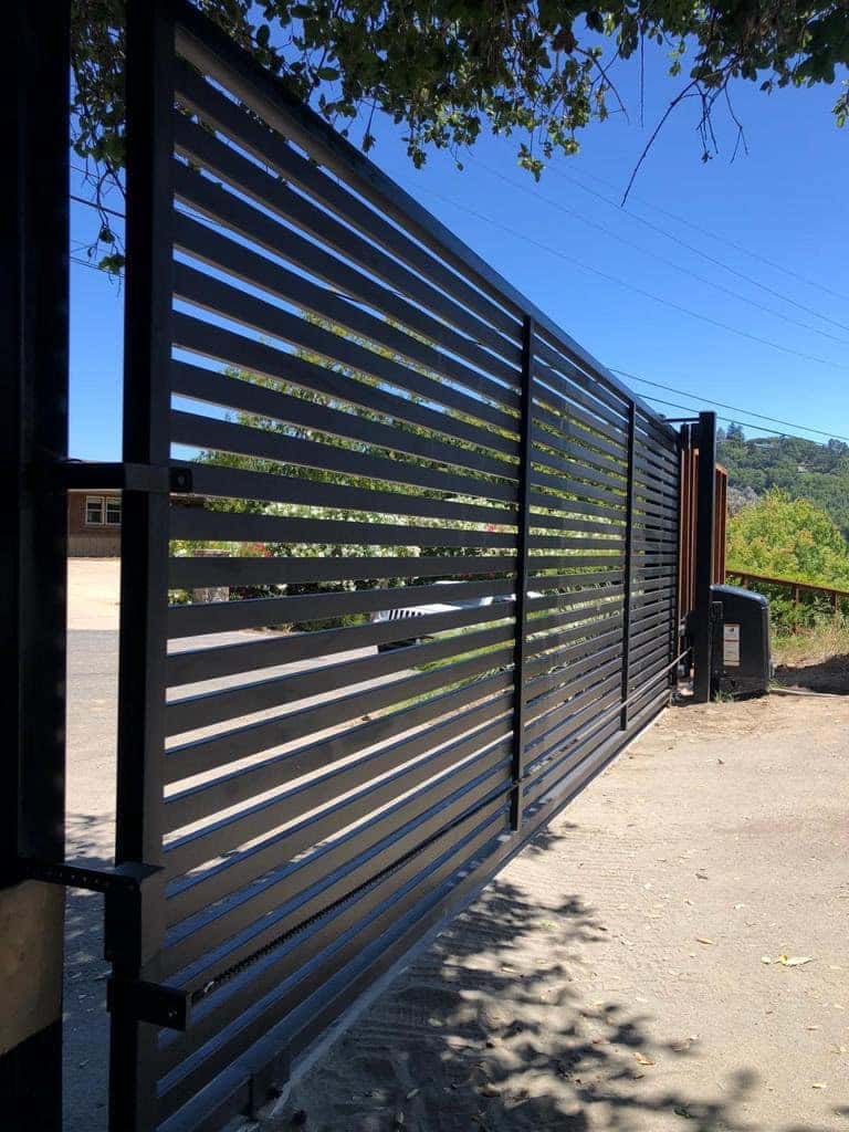 Modern black horizontal-slat driveway gate at a contemporary home